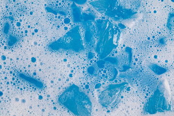 Ice cubes floating in frothy blue matcha beverage