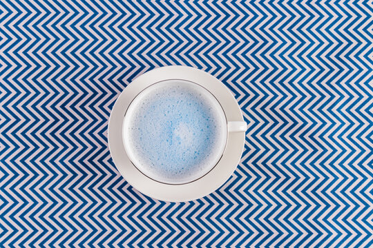 Blue matcha latte in a white cup with zigzag pattern