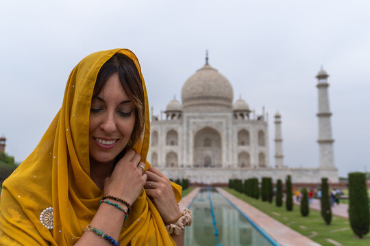 Woman in vibrant sari in front of iconic Indian temple