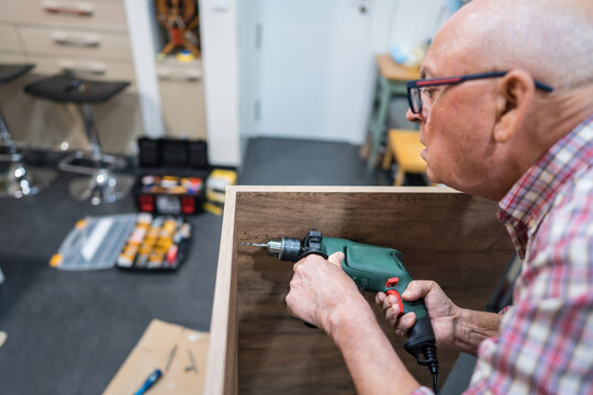 Senior involved in kitchen DIY home renovation - Powered by Adobe