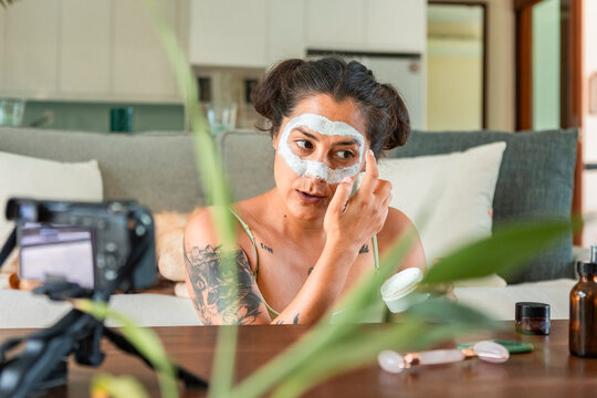 Woman recording skincare tutorial at home