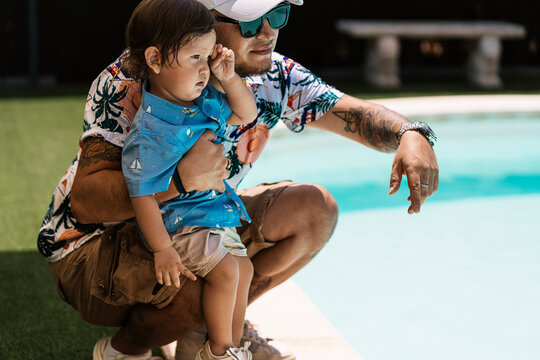 Father and child enjoying a sunny day by the pool