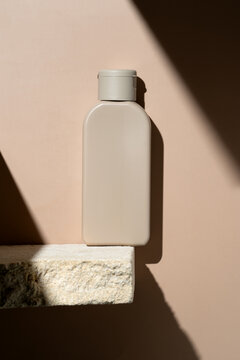 Minimalist cosmetic bottle on textured stone shelf