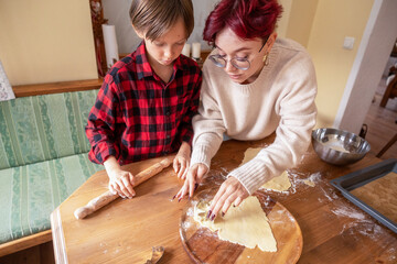 Young woman and child baking Christmas cookies together