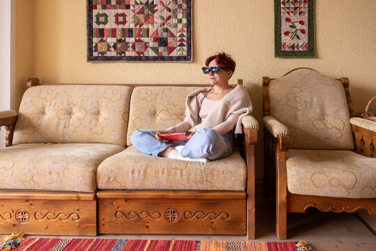 Young woman relaxing on couch with game console