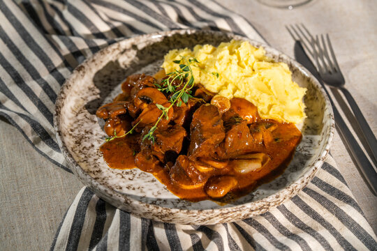 Beef bourguignon with mashed potatoes on rustic plate