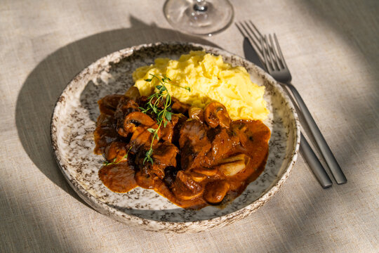 Beef bourguignon with mashed potatoes and herbs