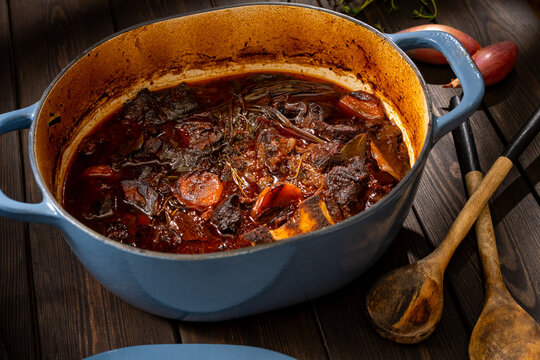 Delicious beef bourguignon in a blue pot on wooden table