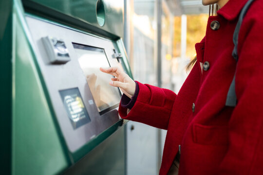 Woman in red using touchscreen in winter setting