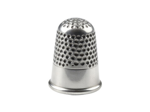 A close-up of a metal thimble sitting on a white surface