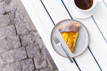 Mango cake slice with coffee on rustic table