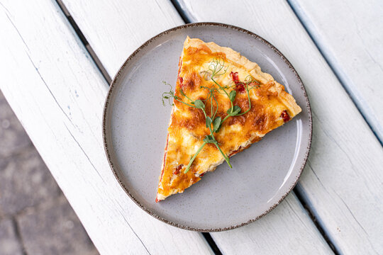Delicious slice of homemade quiche on gray plate