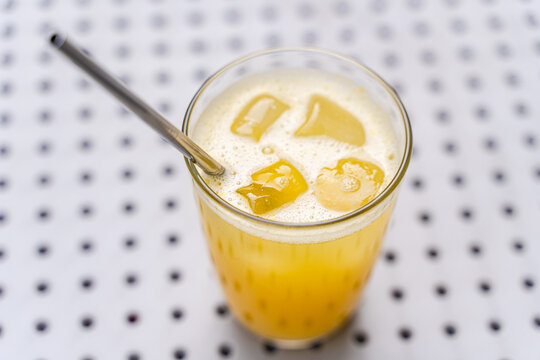 Refreshing glass of orange juice with ice cubes
