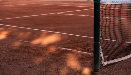 Clay tennis court with net and painted lines