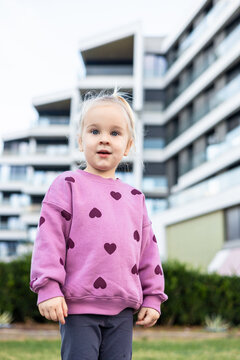 Toddler girl in pink sweater with heart patterns