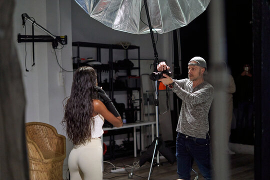 Professional studio photoshoot with model and photographer