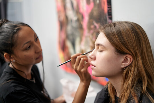 Makeup artist applies touch-ups in creative studio space