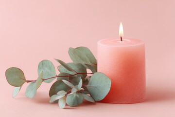 Soft pink candle and eucalyptus sprigs