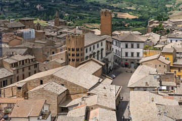 Italy - Orvieto - Church of Sant'Andrea - Romanesque bell tower flanked by striped stone walls and medieval streets