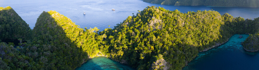 The rock islands of Wyil, composed of ancient, uplifted reefs, rise from the seascape in Misool, Indonesia. This region harbors spectacular marine biological diversity and is a popular destination for