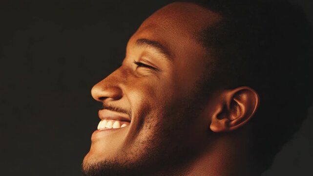 A cheerful young adult male smiling and looking upward with a positive expression
