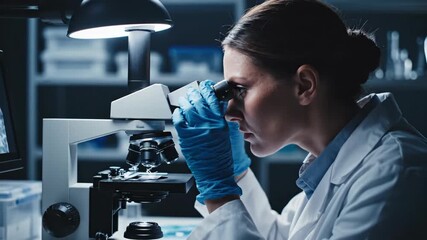 Scientist in a laboratory analyzes samples under a microscope for research. - Powered by Adobe