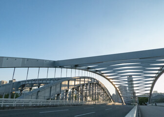 Naklejka premium 夕焼け前の空を背景にした都会のアーチ橋と道路