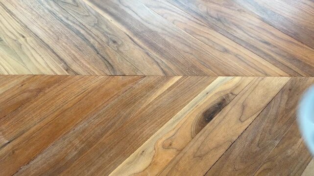 Close up of a hand lifting an empty toddler divided plate from a wooden table. Parenting and child friendly dining concept.