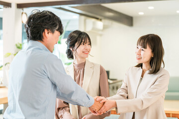 Fototapeta premium Businessman and businesswoman shaking hands to greet, introduce themselves and seal a deal in a corporate office