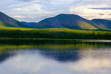 Sunset panorama of small lake with mountain reflection in Siberia, Buryatia, Russia