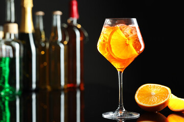 Refreshing spritzer cocktail and orange slices on table in bar. Space for text