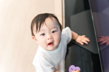 Baby standing up in the living room at home (walking, growth, development)