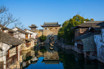 Sunrise view of the Chinese-style ancient architectural complex by the ancient bridge and flowing water in Yanguan Ancient City, Jiaxing, China