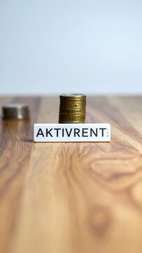 Aktivrent concept with stacked coins on a wooden table, symbolizing financial planning and retirement savings.