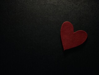 Obraz premium Red Heart Symbol on Black Textured Background, Warm Ambient Glow, Soft Diffused Lighting, Minimalist Composition