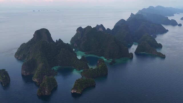 Scenic limestone islands, composed of ancient, uplifted reefs, rise from the seascape in Misool, Indonesia. This region harbors spectacular marine biodiversity and is a popular destination for divers.