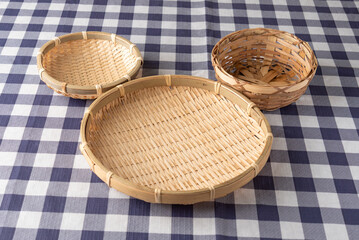 Arrangement of three bamboo baskets forming a silhouette of a face on checkered tablecloth