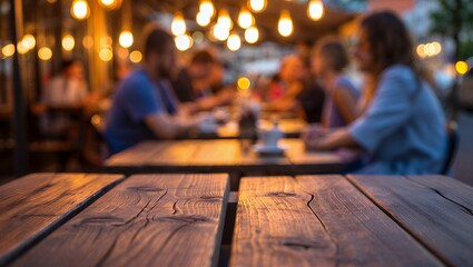 Cozy outdoor dining experience with warm string lights illuminating blurred silhouettes of people enjoying a meal at a rustic wooden table