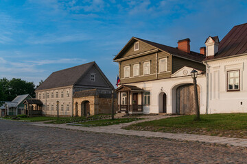 Historical merchant buildings of estates on the main street of Izborsk Pechorskaya Street on a summer sunny day, Izborsk, Pskov region, Russia