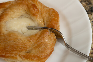 Cream cheese danish being cut with a fork