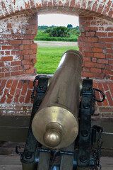 Fort Matanzas: Cannon in brick embrasure overlooks green landscape.