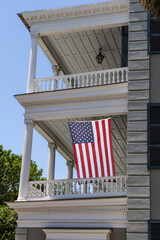 Charleston, SC: American flag on historic columned balcony.