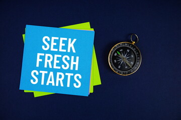 Seek Fresh Starts text written on sticky note with compass on blue  background
