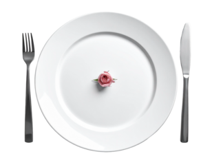 A single rosebud on a white plate with fork and knife.