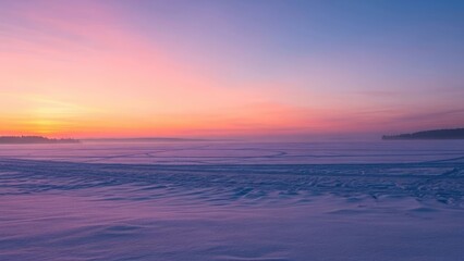 Frosty landscape under a colorful sunrise with snow and trees in distance