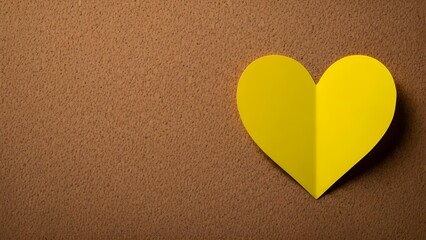 Fototapeta premium A bright yellow paper heart on a brown background simple and symbolic