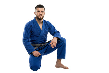 Naklejka premium Male Martial Artist in Blue Gi Kneeling Pose Studio Shot