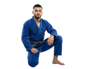 Male Martial Artist in Blue Gi Kneeling Pose Studio Shot