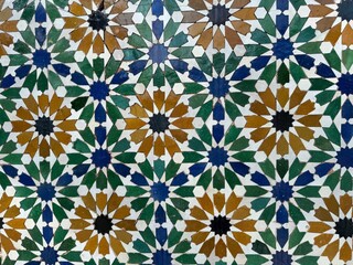 Intricate Islamic geometric tile pattern with 12 points stars in green, blue, brown, black and white, showcasing cultural heritage and architecture artistry. 