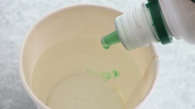 水にうがい薬を入れる人物の動画